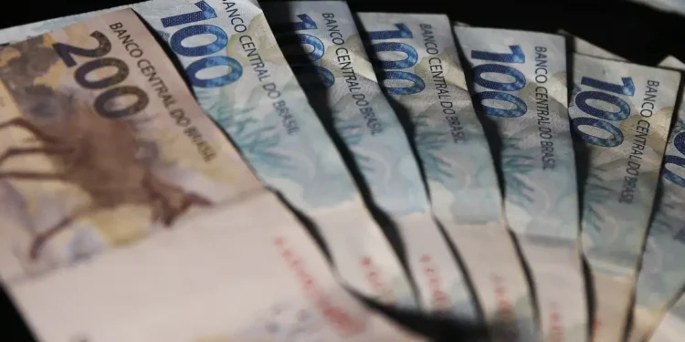 Cédulas de duzentos e cem reais em destaque representando o pagamento do 13º salário dos aposentados e pensionistas do INSS