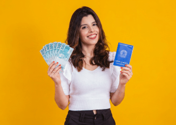 Jovem celebra benefícios trabalhistas com carteira assinada e dinheiro.
