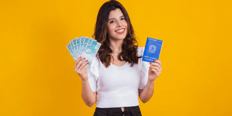 Jovem celebra benefícios trabalhistas com carteira assinada e dinheiro.