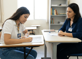 Estudante autista realiza prova do ENEM com apoio de fiscal.