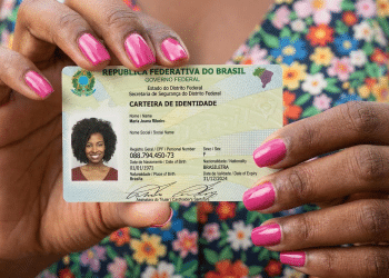 Mulher exibe nova carteira de identidade do Brasil.