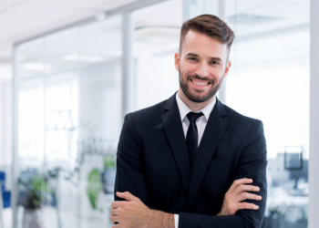 Jovem advogado sorrindo em ambiente de trabalho.
