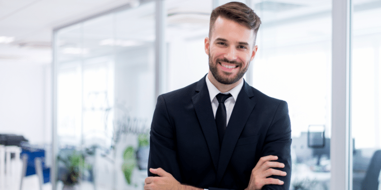 Jovem advogado sorrindo em ambiente de trabalho.