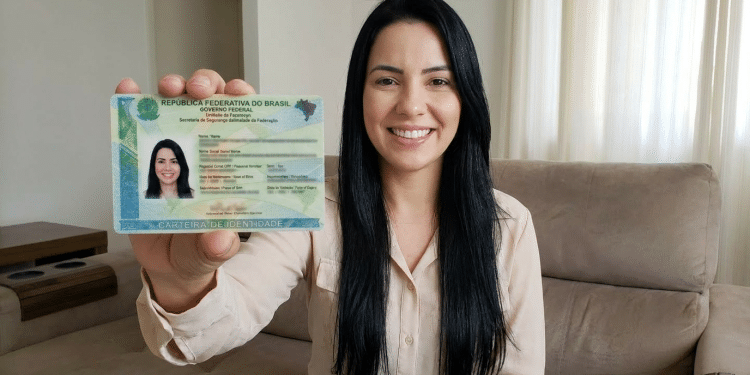 Mulher exibe nova carteira de identidade brasileira em casa.