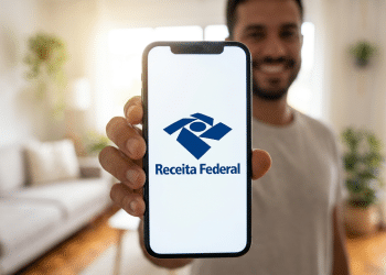 Homem exibe aplicativo da Receita Federal em celular com ambiente doméstico moderno.
