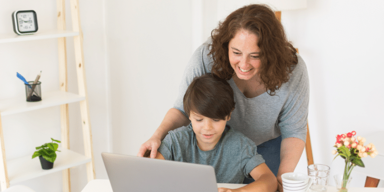 Mães ensinando o filho a mexer no notebook.