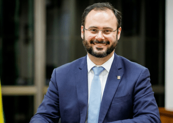 Ministro Paulo Pereira em gabinete oficial com bandeira nacional.