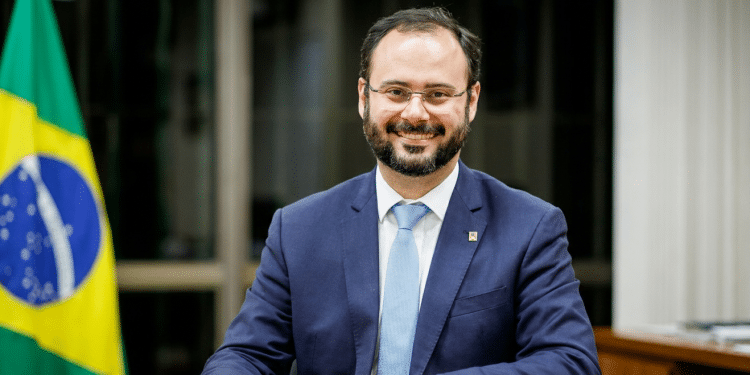 Ministro Paulo Pereira em gabinete oficial com bandeira nacional.