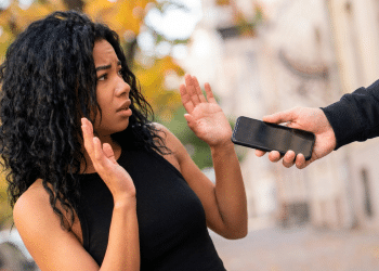 Mulher assustada enquanto homem rouba seu celular.