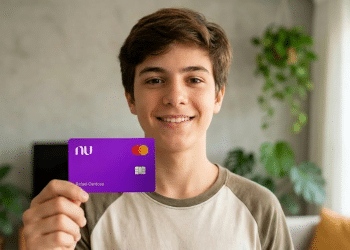 Jovem sorridente exibe cartão Nubank em casa iluminada.