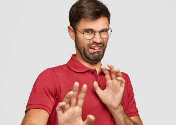 Homem expressando nojo em destaque com camisa vermelha.