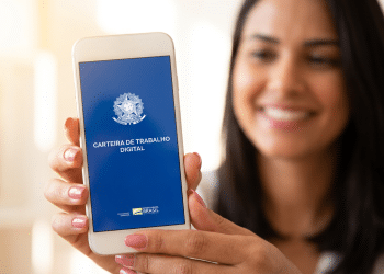 Mulher exibe Carteira de Trabalho Digital em celular com sorriso.