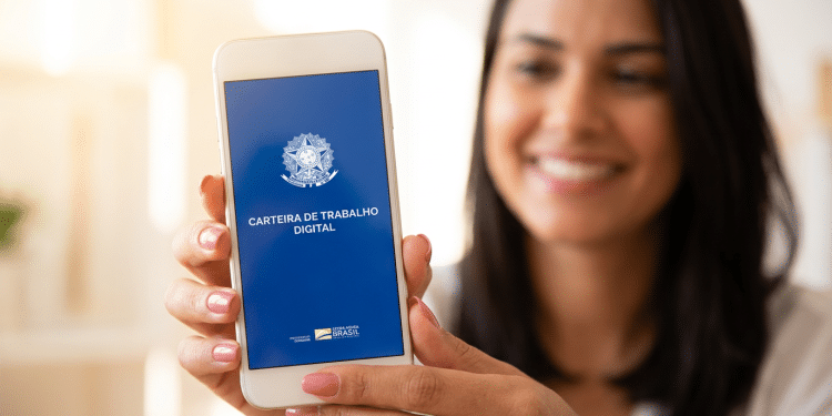 Mulher exibe Carteira de Trabalho Digital em celular com sorriso.