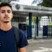 Estudante em frente a faculdade, representando o período de adesão das instituições ao Fies.