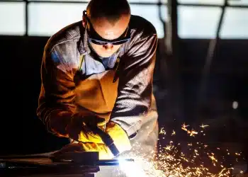 Profissional de soldagem usando equipamento de proteção, simbolizando trabalhadores expostos a riscos que podem solicitar aposentadoria especial do INSS.