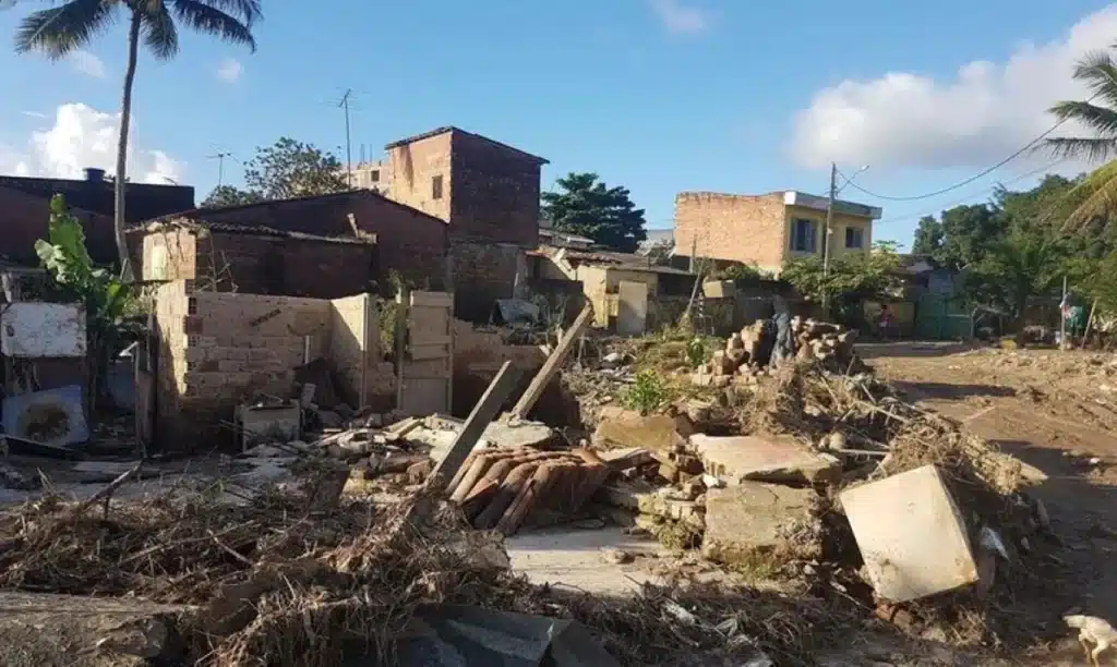 Casas danificadas em área atingida por calamidade pública, representando a liberação do pagamento unificado do Bolsa Família em junho.