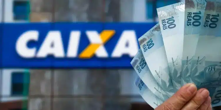 Cédulas de R$ 100 em frente a uma agência da Caixa Econômica Federal ilustram o pagamento de R$ 1.050 do Bolsa Família.
