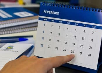 Pessoa aponta para um calendário de mesa de fevereiro que termina no dia 28, sem o dia 29 do ano bissexto