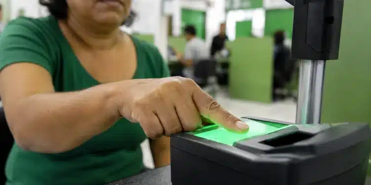 Pessoa realizando coleta de impressão digital em estação de biometria para emissão da nova Carteira de Identidade.