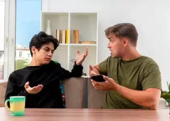 Dois jovens conversam em clima de tensão, representando atitudes passivo-agressivas e dificuldade de comunicação.