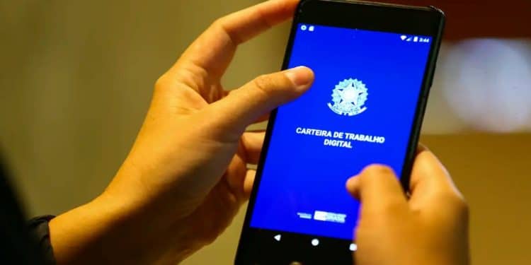 Mãos segurando um celular com o aplicativo Carteira de Trabalho Digital aberto, ferramenta usada para consultar o Abono Salarial do PIS/Pasep em 2026