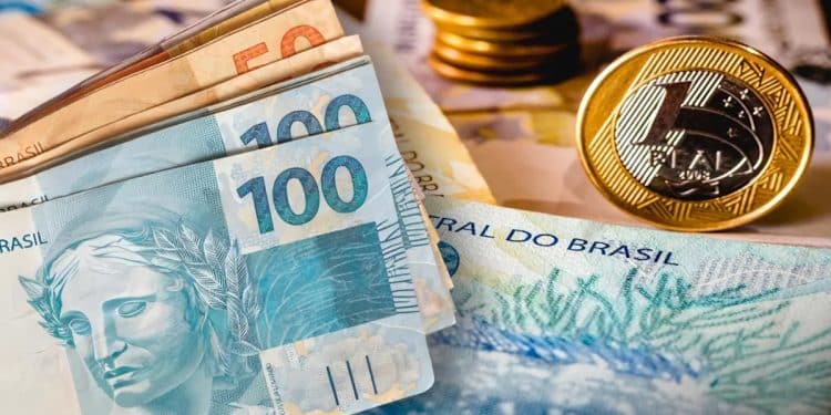Cédulas de R$ 50 e R$ 100 e moeda de R$ 1 sobre notas do Banco Central, representando o dinheiro esquecido que pode ser resgatado no Sistema de Valores a Receber.