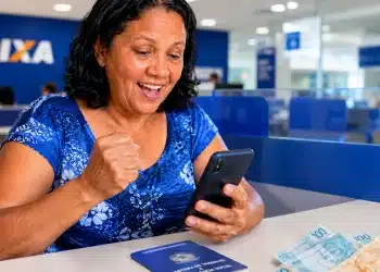 Mulher consultando no celular se tem valores do PIS/PASEP de 1971 a 1988 para sacar