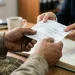 Trabalhador recebe contracheque impresso durante atendimento em escritório.