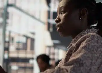 Mulher negra em ambiente urbano ilustra desigualdades no acesso ao emprego.