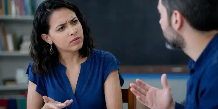 Duas pessoas em debate em sala de aula, representando a dúvida entre usar “degladiar” ou “digladiar”.