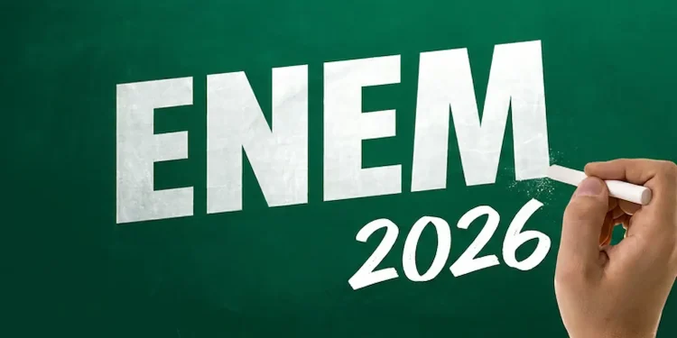 Mão escrevendo “ENEM 2026” em um quadro verde, ilustrando o prazo para pagamento da taxa de inscrição até 10 de junho.