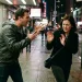 Homem alterado gesticula durante discussão enquanto mulher demonstra medo e tenta se afastar em uma rua à noite.