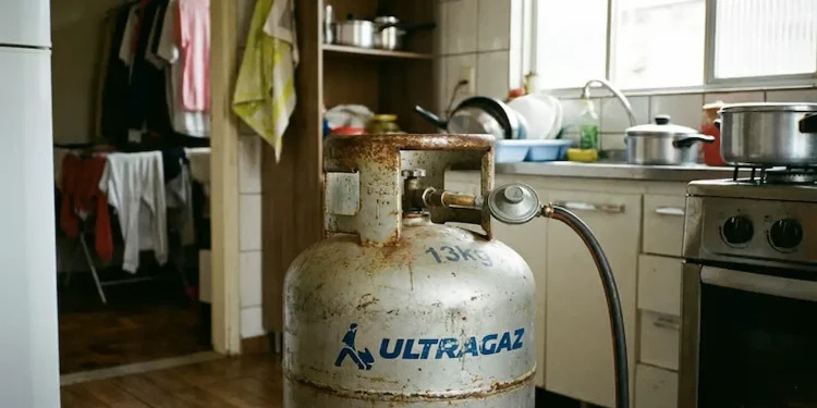 Botijão de gás de cozinha conectado em cozinha residencial com uso diário.