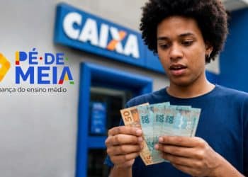 Jovem conta notas de R$ 50 e R$ 100 em frente a uma agência da Caixa, representando o pagamento de R$ 1.000 do Pé-de-Meia.