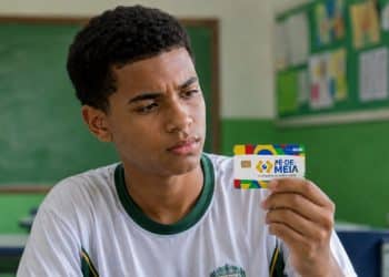 Estudante observa o cartão do Pé-de-Meia, que dá acesso ao Incentivo-Conclusão.