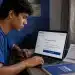 Estudante brasileiro acessando página de inscrição do Enem 2026 em notebook com boleto de pagamento sobre a mesa