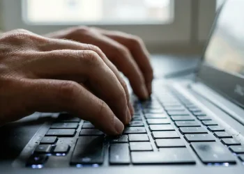 Mãos digitando em notebook representando inscrição no curso online sobre IA no Excel oferecido gratuitamente pelo Senac RJ.