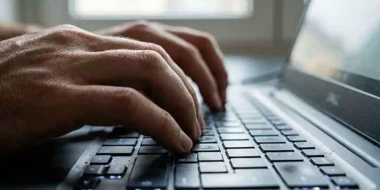 Mãos digitando em notebook representando inscrição no curso online sobre IA no Excel oferecido gratuitamente pelo Senac RJ.