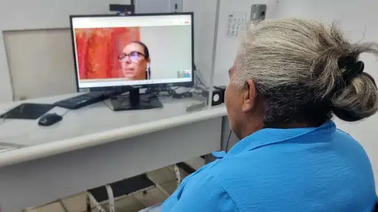 Idosa em atendimento por videoconferência em unidade do INSS, representando a modernização dos serviços previdenciários e a antecipação de perícias médicas.