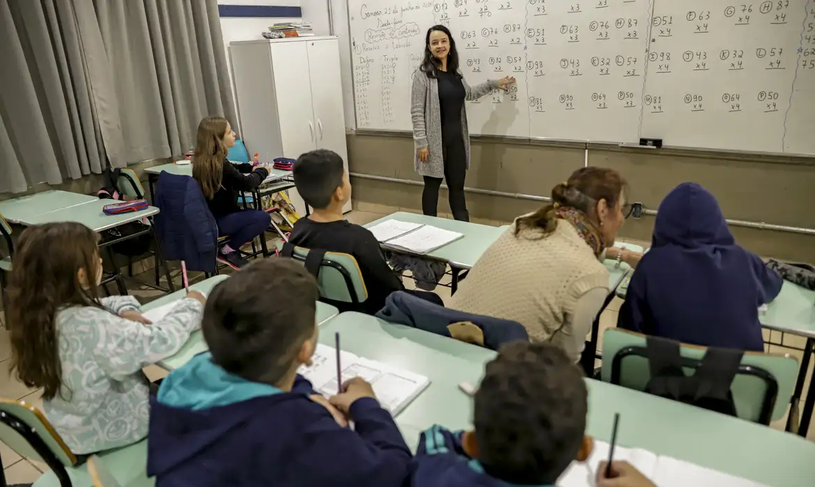 Professora dá aula em escola pública, carreira que teve o piso reajustado e a nova regra de cálculo definida em lei