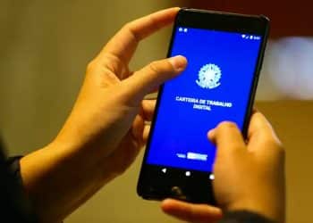 Mãos seguram celular com o aplicativo da Carteira de Trabalho Digital aberto na tela