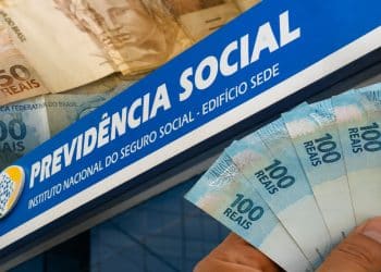 Placa da Previdência Social ao lado de cédulas de real representando os pagamentos do INSS de junho de 2026