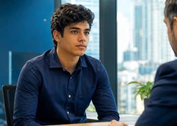 Jovem de camisa azul ouve o recrutador em uma entrevista de emprego, momento em que são feitas as cinco perguntas mais comuns para candidatos da Geração Z