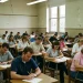 Candidatos realizam prova em sala de aula, representando profissões que exigem exames ou concursos após a faculdade.
