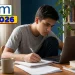 Estudante se prepara para a redação do Enem 2026 usando notebook e caderno, com destaque para o tema tecnologia e IA.