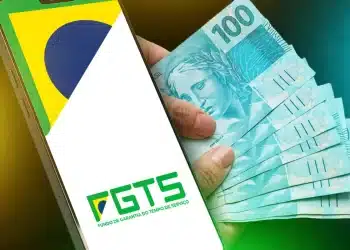 Imagem ilustrativa do saque calamidade do FGTS com celular e cédulas de dinheiro.