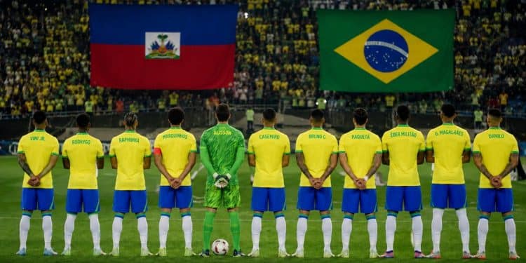 Imagem ilustrativa de jogadores da Seleção Brasileira perfilados em campo diante das bandeiras do Haiti e do Brasil, em referência ao jogo Brasil x Haiti pela Copa do Mundo 2026