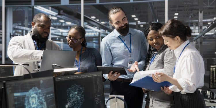 Equipe de profissionais de tecnologia analisa dados em monitores e tablet, representando os setores que pagam bônus acima de 30% do salário-base.