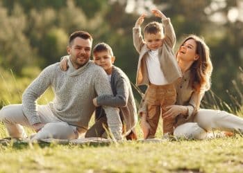 Família reunida ao ar livre ilustra a discussão entre ter filhos e felicidade no dia a dia