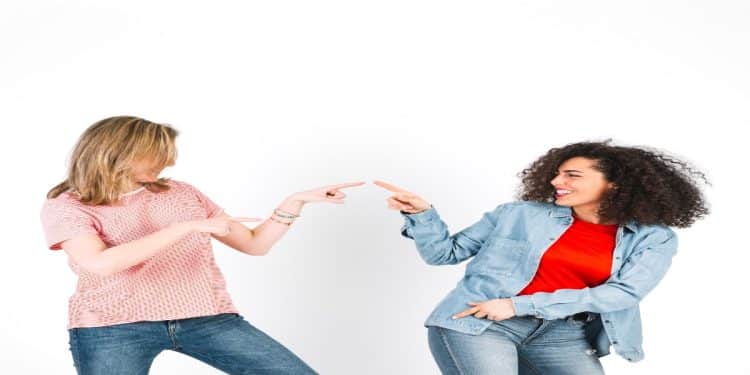 Duas mulheres sorriem e se olham frente a frente, representando o contato visual prolongado durante uma conversa